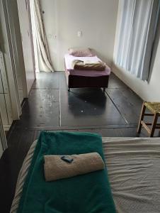 a room with a bed with a green blanket on the floor at Hotel & Restaurante Frezza in Francisco Beltrão