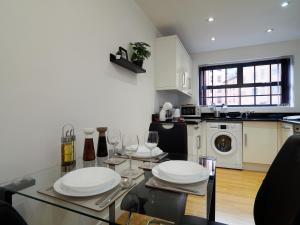 a kitchen with a table with plates and wine glasses at West Point, Derby city centre in Derby