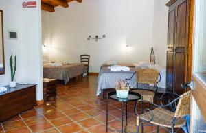 a room with a bed and a table and chairs at Casale Ginisara in Castellammare del Golfo