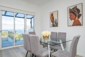 a dining room with a glass table and chairs at Villa Ana D'Arfet in Água de Pena