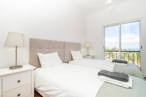 1 dormitorio blanco con 2 camas y ventana en Villa Ana D'Arfet, en Água de Pena