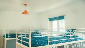 a bedroom with two bunk beds with a window at 70's Hostel in Ericeira