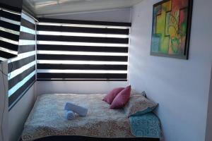 Una cama pequeña en una habitación con ventana. en Apartamento en el Corazón de Paipa., en Paipa