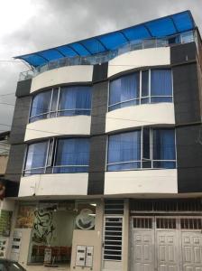 un edificio grande con muchas ventanas en Apartamento en el Corazón de Paipa., en Paipa 3 fotos más