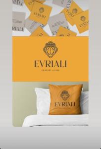a logo for a hotel with a pillow on a bed at Evriali Comfort Living in Palaiochóra