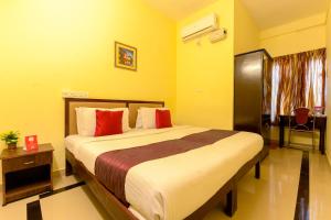 a bedroom with a large bed with red pillows at Super OYO Flagship Hotel Diamond In in Kakkanad