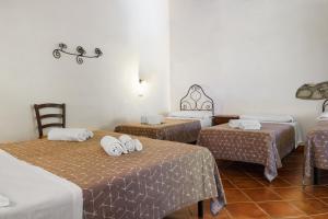 a room with three beds with towels on them at Casale Ginisara in Castellammare del Golfo