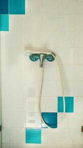 a shower head in a bathroom with blue and white tiles at 70's Hostel in Ericeira