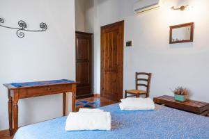 a bedroom with a bed and a desk and a chair at Casale Ginisara in Castellammare del Golfo