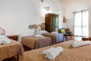 a room with three beds with towels on them at Casale Ginisara in Castellammare del Golfo
