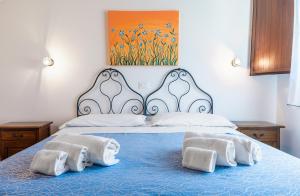 a bedroom with a blue bed with towels on it at Casale Ginisara in Castellammare del Golfo