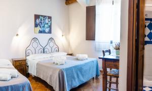 a room with two beds and a table at Casale Ginisara in Castellammare del Golfo