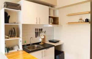 a kitchen with white cabinets and a sink at Modern Japanese inspired studio at Avida Towers Atria in Iloilo City