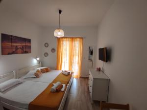 1 dormitorio con 2 camas, vestidor y ventana en ANGEL STUDIOS VRACHOS BEACH PREVEZA, en Vrachos