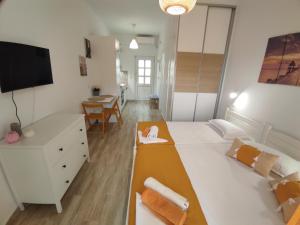 Un dormitorio con una gran cama blanca y una mesa en ANGEL STUDIOS VRACHOS BEACH PREVEZA, en Vrachos