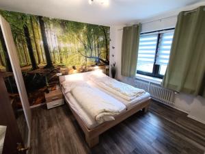 ein Schlafzimmer mit einem Bett und einem Gemälde an der Wand in der Unterkunft Landhaus Dahlem in Hahnenklee-Bockswiese