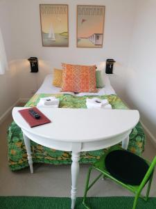 um quarto com uma cama com uma mesa branca e cadeiras em Femmasteren Hotel & Hostel em Marstal