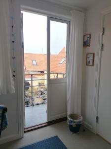 an open door with a view of a balcony at Femmasteren Hotel & Hostel in Marstal