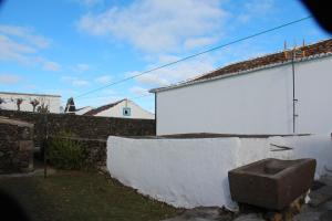 a white building with a stone wall next to it at Casa do Sr. Alberto in Praia da Vitória +18 photos
