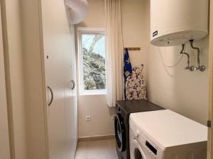 a kitchen with a washing machine and a window at Blue Emerald Beachfront Blessing in Willemstad +22 photos