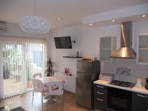 a kitchen with a stove and a table with chairs at Apartment Teuta in Zadar
