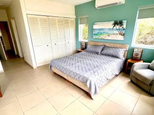 1 dormitorio con 1 cama y 1 sofá en Blue Emerald Beachfront Blessing en Willemstad