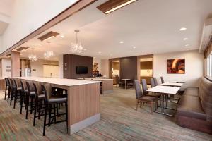 a lobby with a large bar with chairs and tables at Residence Inn San Angelo in San Angelo