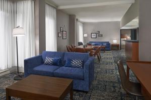 a living room with a blue couch and a table at Four Points by Sheraton Hotel & Conference Centre Gatineau-Ottawa in Gatineau