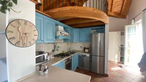una cucina con armadi blu e un orologio sul muro di Il Mulino di Hotel Villa Aurora a Nesso