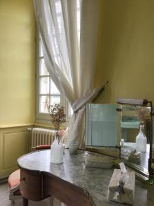 a room with a table with a mirror and a window at Chateau du Fraisse in Nouic