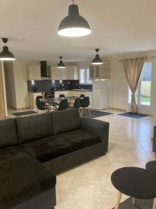 een woonkamer met een bank en een keuken bij Maison entière proche du centre le Bugue in Le Bugue