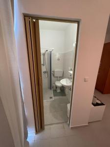 a bathroom with a toilet and a glass door at IL PONTE room4 in Asklipiḯon