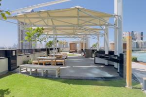 a pavilion on the roof of a building with tables and benches at GuestReady - Palms at heaven's door in Dubai