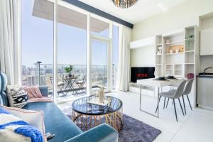 a living room with a blue couch and a table at GuestReady - Palms at heaven's door in Dubai