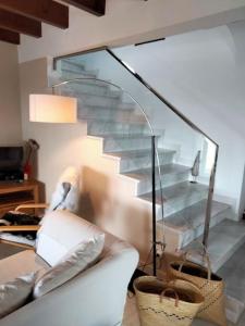 ein Wohnzimmer mit einem Sofa und einer Glastreppe in der Unterkunft Villa Amor in Cala Morell
