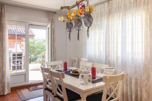 a dining room with a white table and chairs at Chalet junto a playa de Suances in Suances