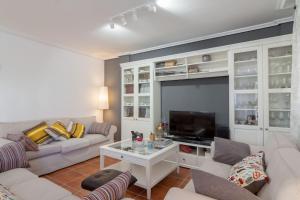 a living room with a couch and a tv at Chalet junto a playa de Suances in Suances