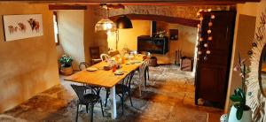 uma sala de jantar com uma mesa de madeira e cadeiras em Aux coeurs du Méjean 
