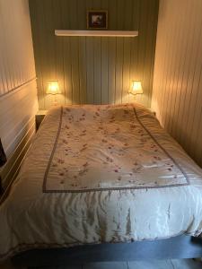 a bedroom with a bed with two lamps on it at Verningen Apartment in Larvik