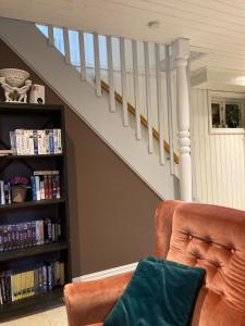 eine Treppe mit einer Couch und einem Bücherregal mit Büchern in der Unterkunft Verningen Apartment in Larvik