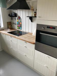 a kitchen with white cabinets and a stove at Verningen Apartment in Larvik