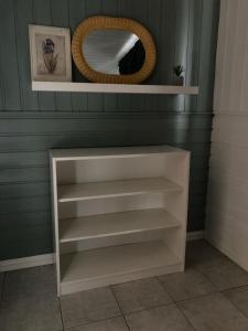 a white shelf in a room with a mirror at Verningen Apartment in Larvik