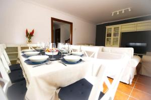 a dining room with a white table and white chairs at Chalet junto a playa de Suances in Suances
