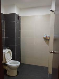 Łazienka z toaletą i czarno-białą ścianą w obiekcie Armada Sweet Homestay w mieście Gua Musang