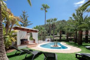 a backyard with a swimming pool and palm trees at CAN TEO - Holiday Villa in Ibiza in Ibiza Town