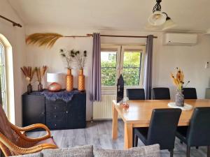 jadalnia ze stołem i krzesłami oraz oknem w obiekcie De droom van Zeeland met jacuzzi & Finse sauna w mieście Sint Annaland