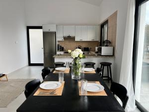 uma mesa preta com pratos e flores numa cozinha em Zeus Holiday Home em Pissouri