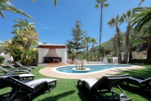 イビサ・タウンにあるCAN TEO - Holiday Villa in Ibizaの芝生の椅子とガゼボ付きのプール
