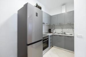 een witte keuken met een koelkast en een wastafel bij Tirana Center Apartment 12 in Tirana