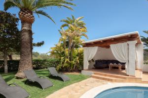 a villa with a swimming pool and a palm tree at CAN TEO - Holiday Villa in Ibiza in Ibiza Town